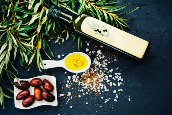Olives and olive oil on table
