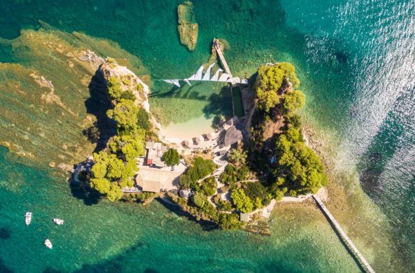 Small Greek islet surrounded by clear green water